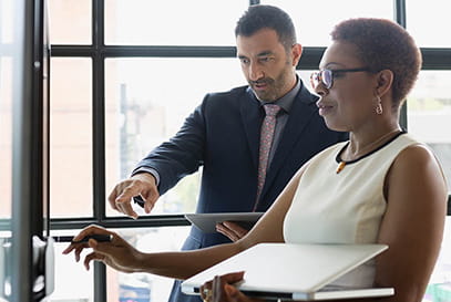 Caucasian male and African American female reviewing charts
