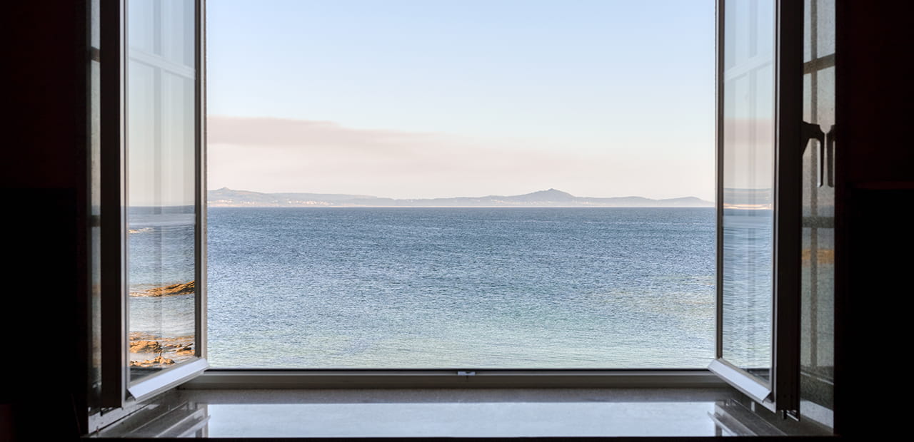 Open window overlooking calm ocean, symbolizing the health benefits of gratitude.