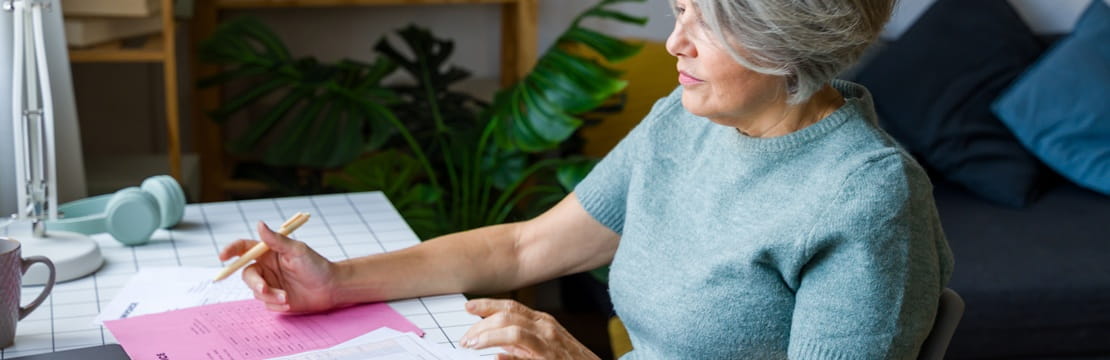A retired woman reviewing her personal finances to align debt management with wealth-building goals.