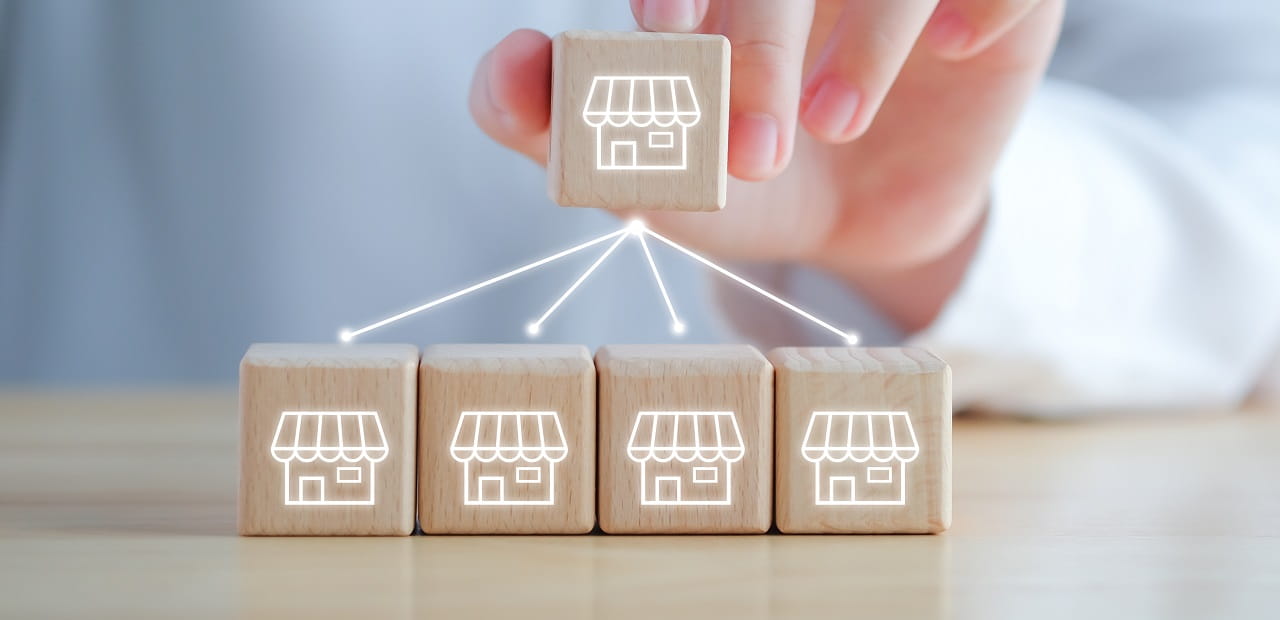 Hand holds a wooden block with arrows pointing downwards towards other blocks.
