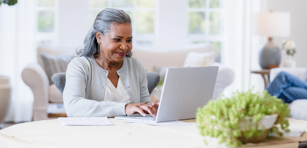 Black woman sits at her computer answering emails.